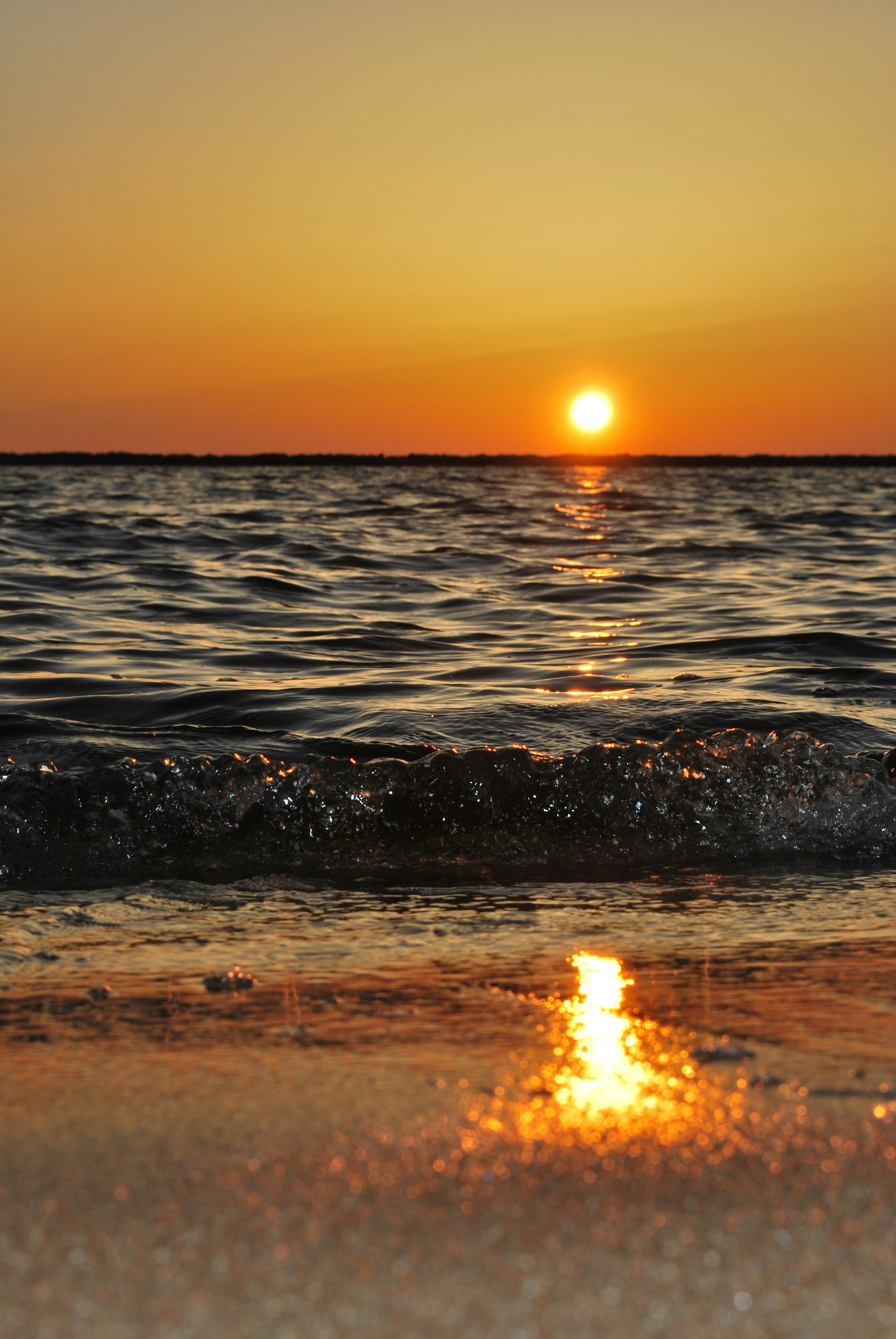 Beautiful beach sunset with golden reflections on calm waters